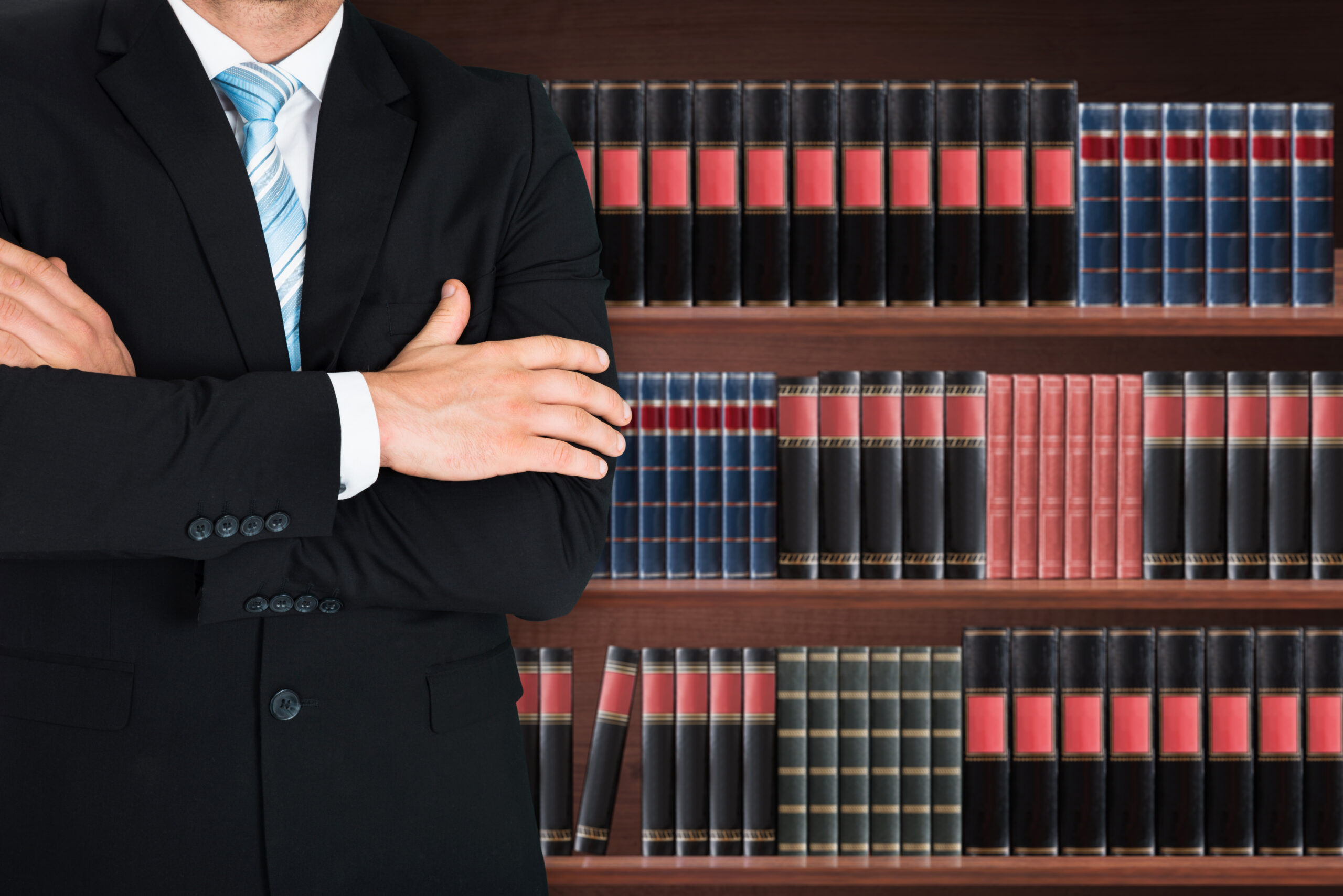 a lawyer standing in front of a bookcase filled with legal books