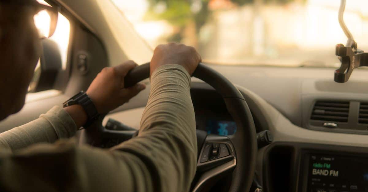 back view of a person turning a steering wheel