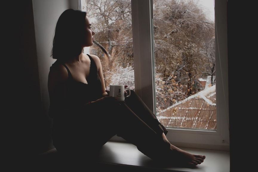 woman sitting and looking out window