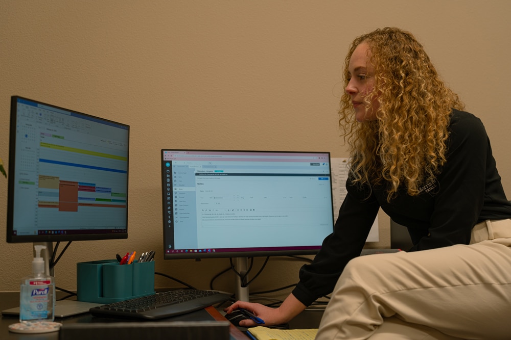 Woman sitting on a desk while browsing on the computer