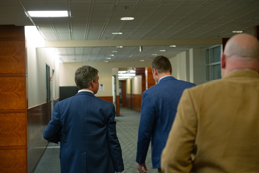 Group of men walking down a hallway
