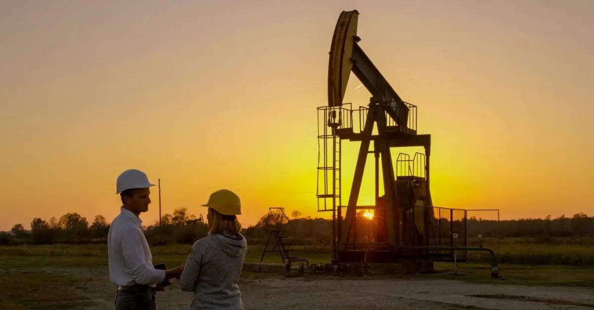 Two managers standing in front of oil rig