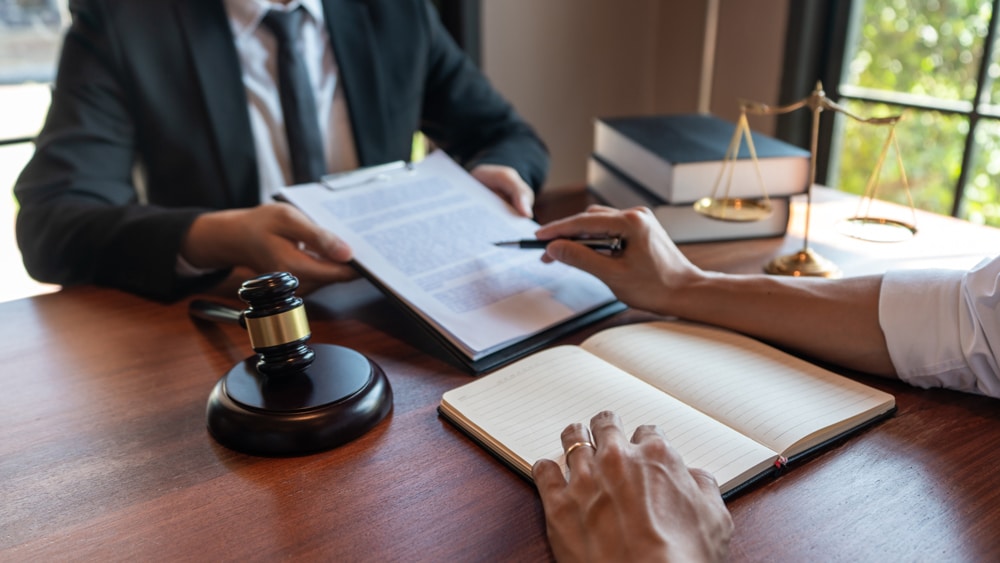 Male notary lawyer or judge consult or discussing contract papers with businessman client in office