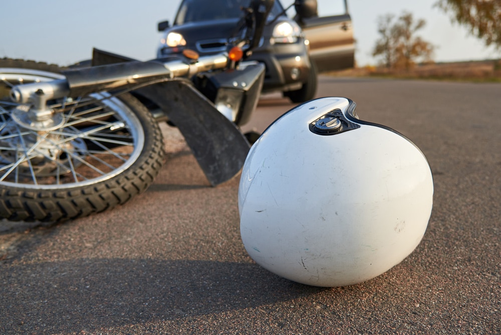 Photo of car, helmet and motorcycle on road, the concept of road accidents.