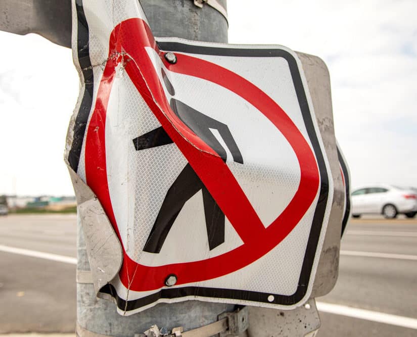 A no pedestrian crossing sign that was damaged due to a car accident