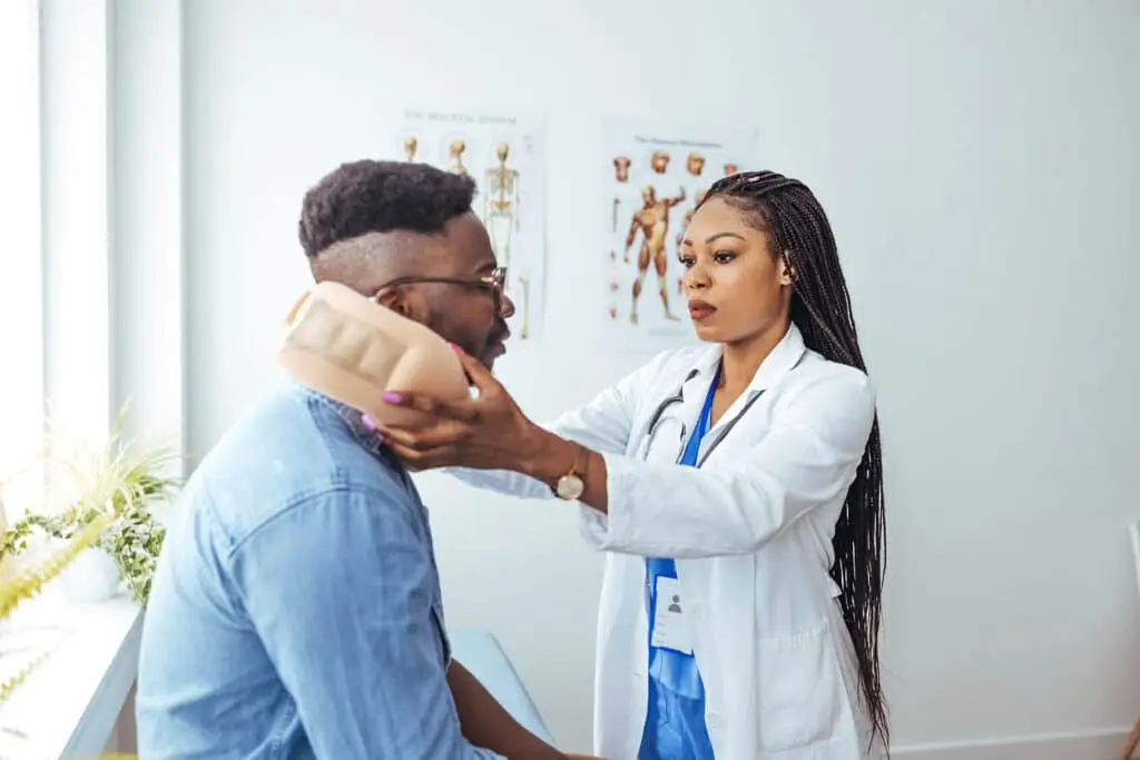 African american man wearing neck brace listening to doctor at hospital.