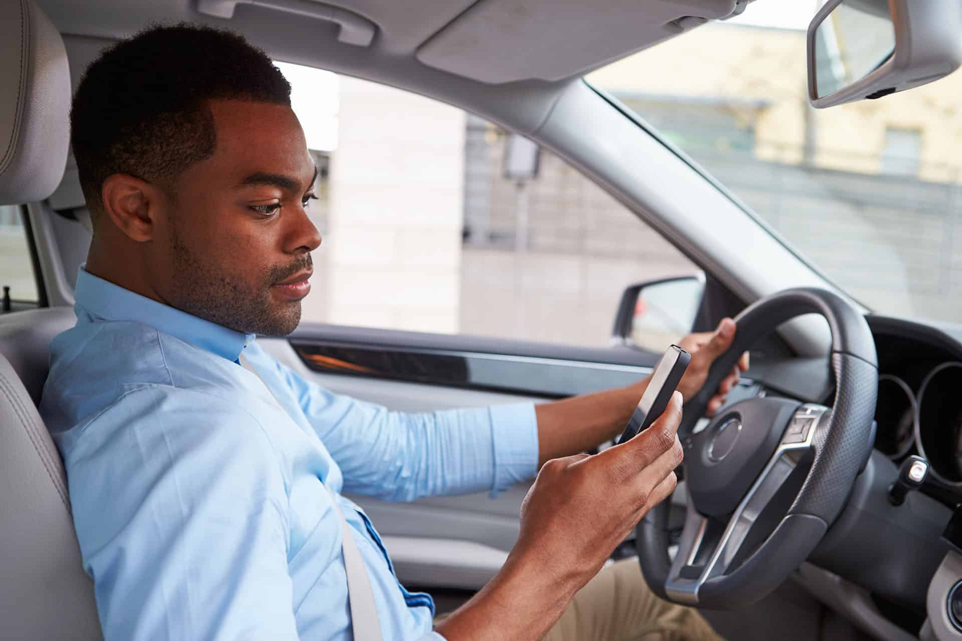 Young african american male driver using phone,