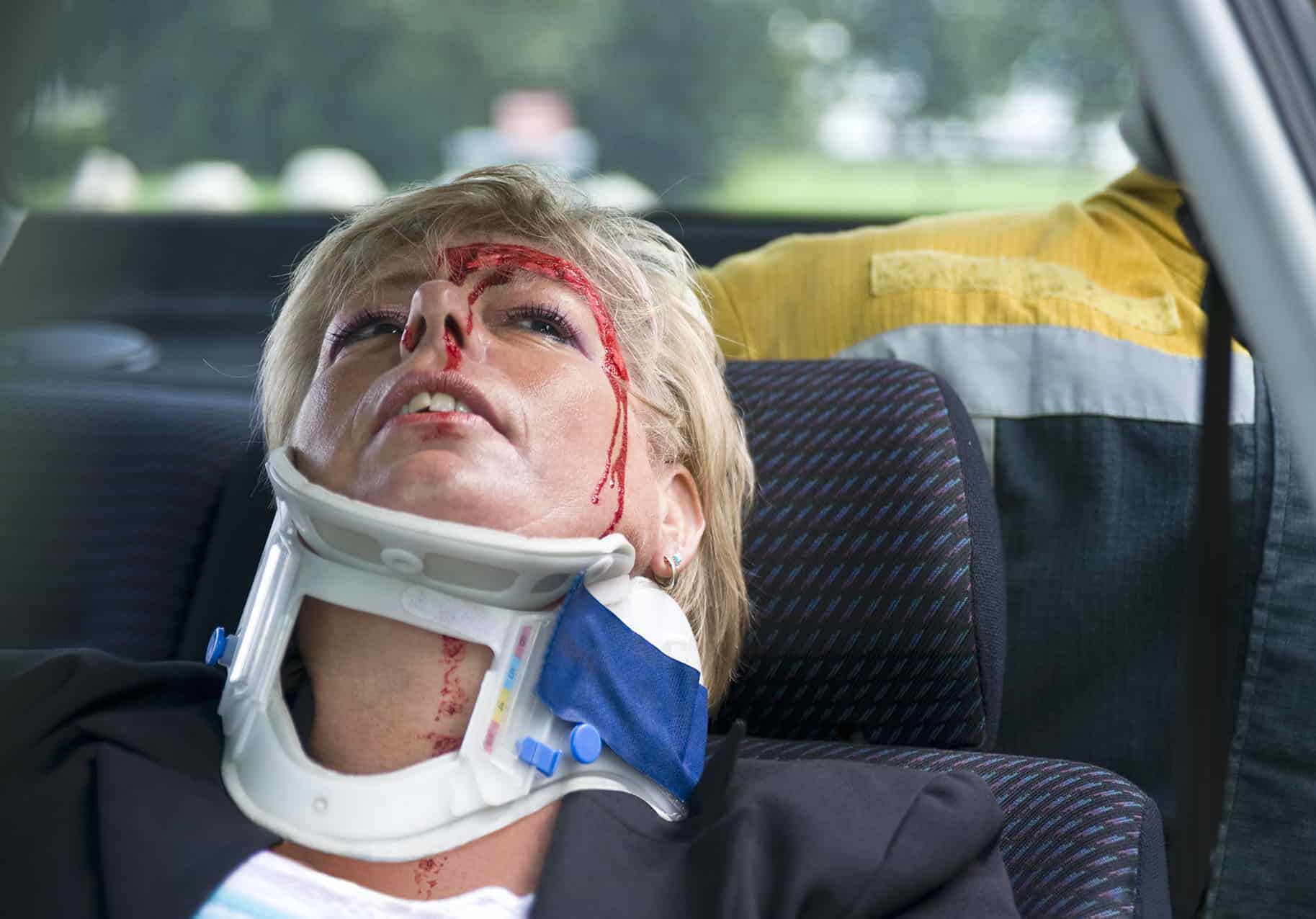 Neck brace around a woman's neck to support her spinal cord after a severe car accident
