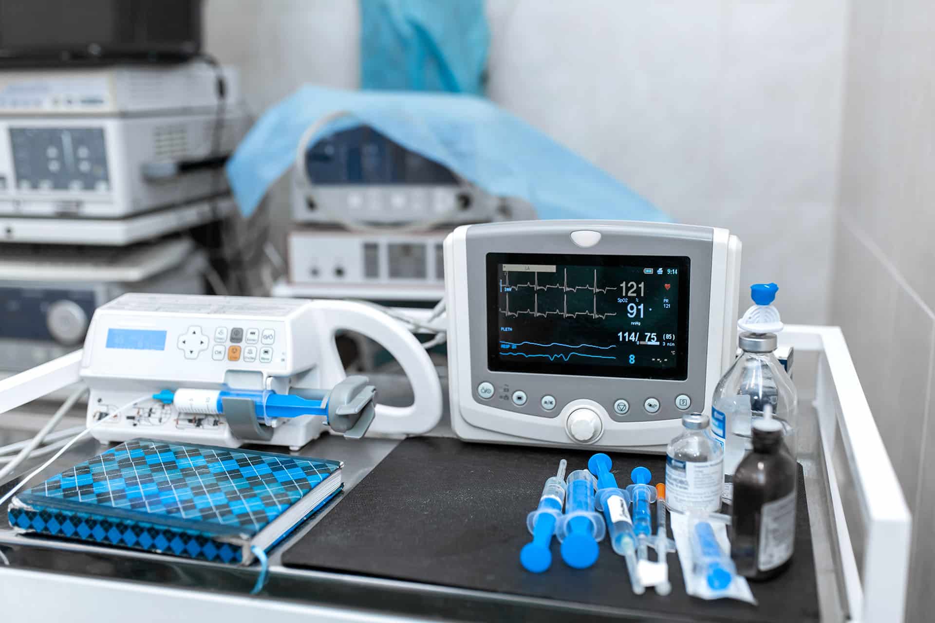 Cardiac monitor and syringe at operating table