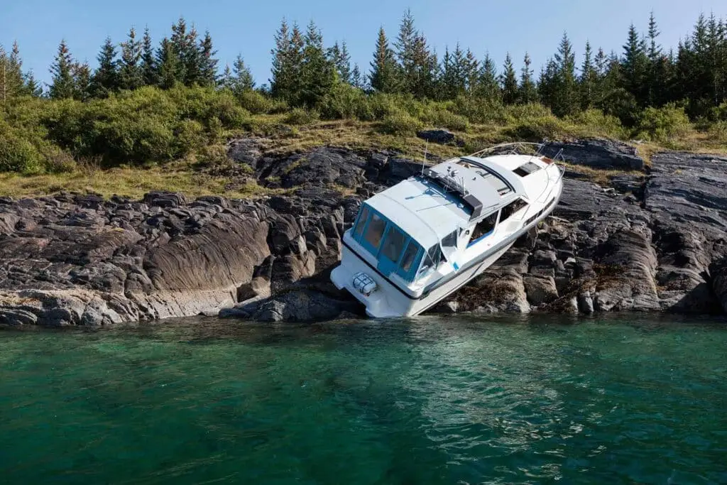 Photo of recreational boat on dry land after collision with rocks