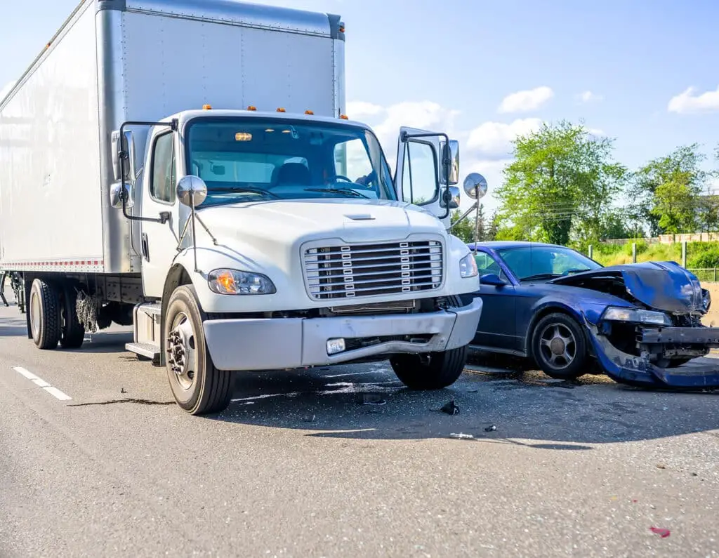 Collision of a semi truck with box trailer a passenger car on the highway road