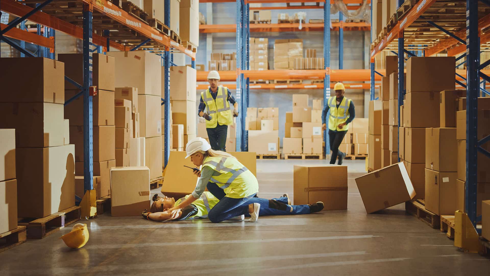 Warehouse worker has work related accident falls while trying to pick up cardboard box from the shelf.