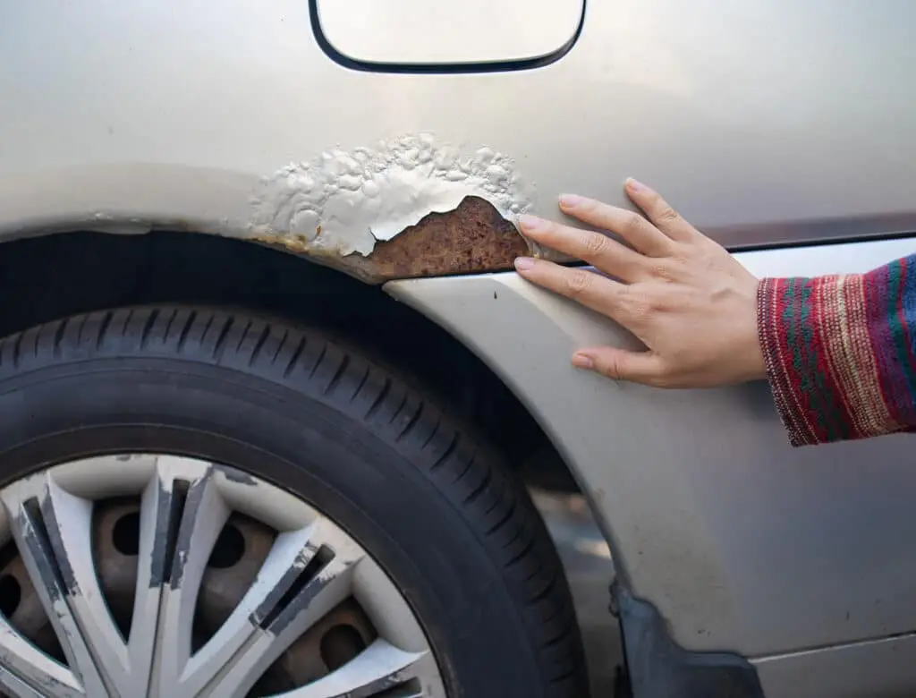 The rusty right fender is covered with a corroded iron defect.