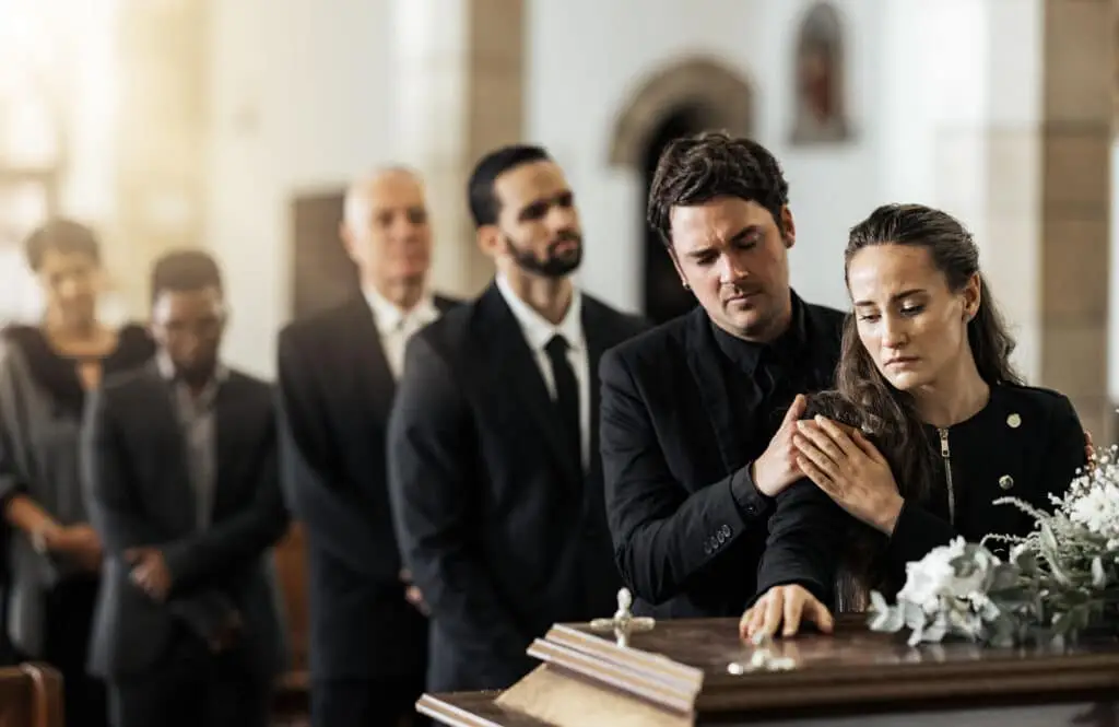 Family touching coffin in a church