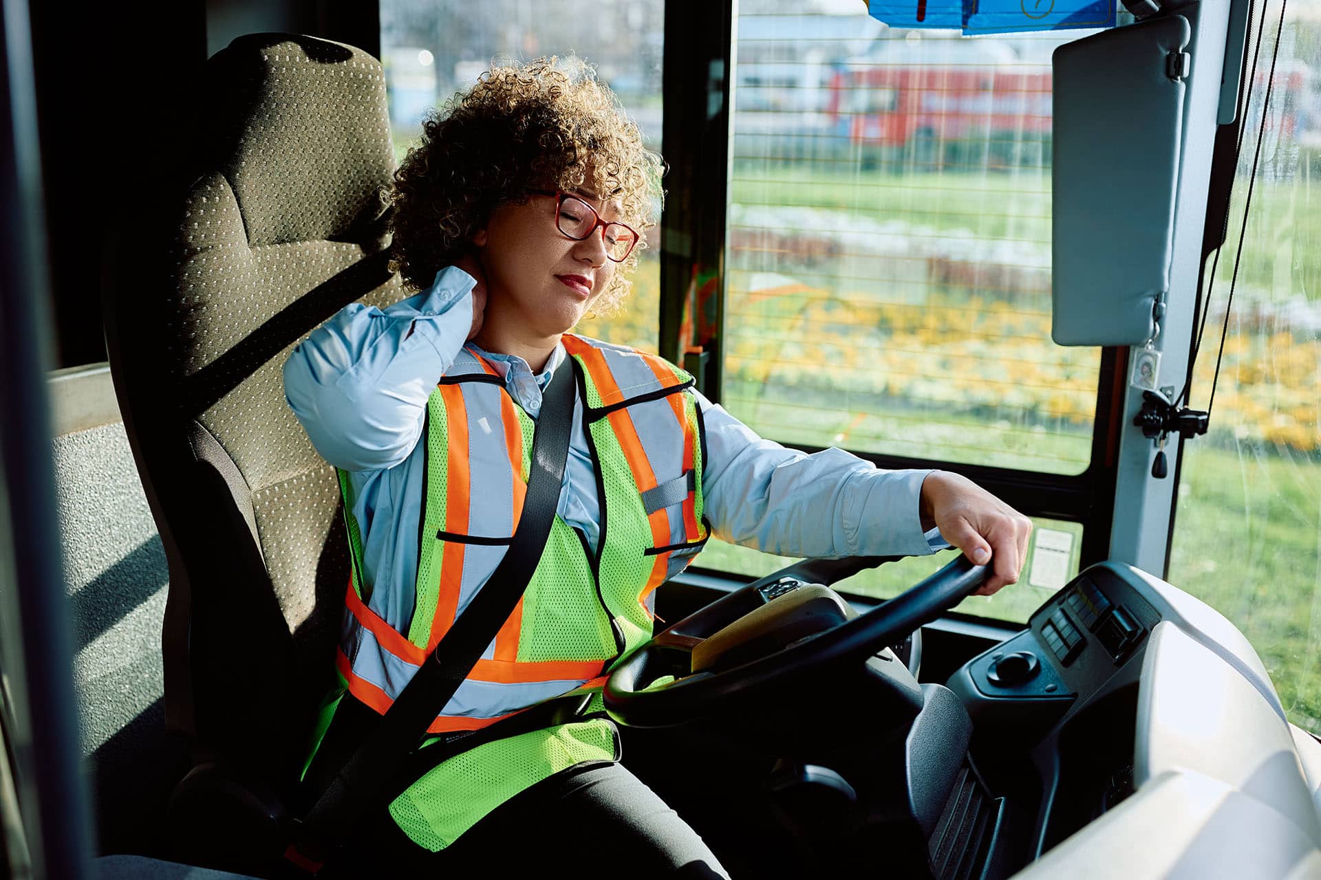 Tired bus driver experiencing pain in her neck after driving a bus.
