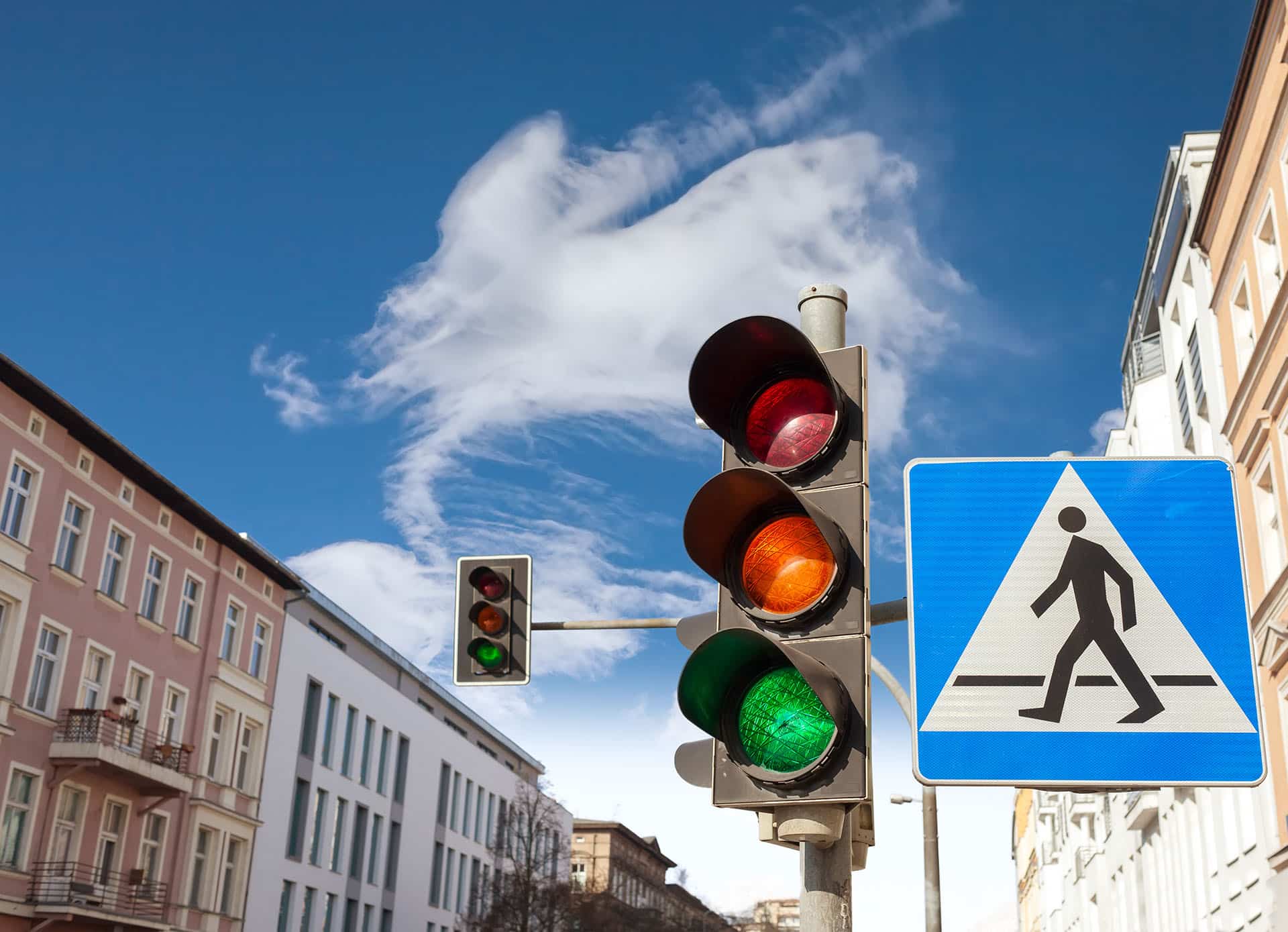 Traffic lights and pedestrian crossing sign in a city.