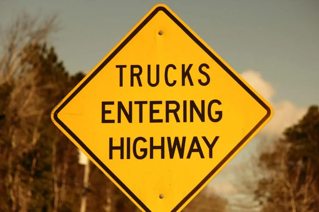 Trucks entering highway sign