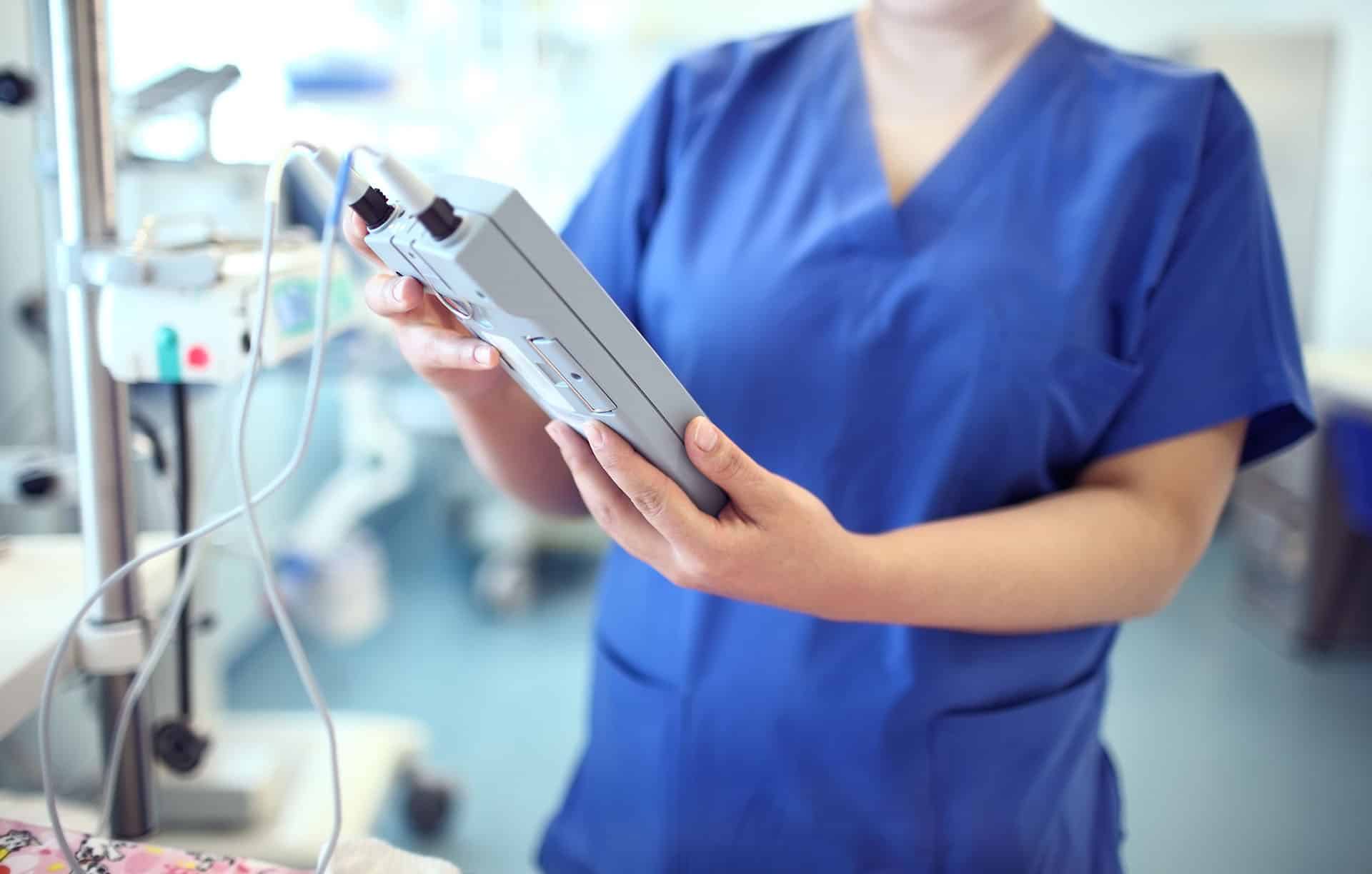 Female doctor adjust electronic medical device.