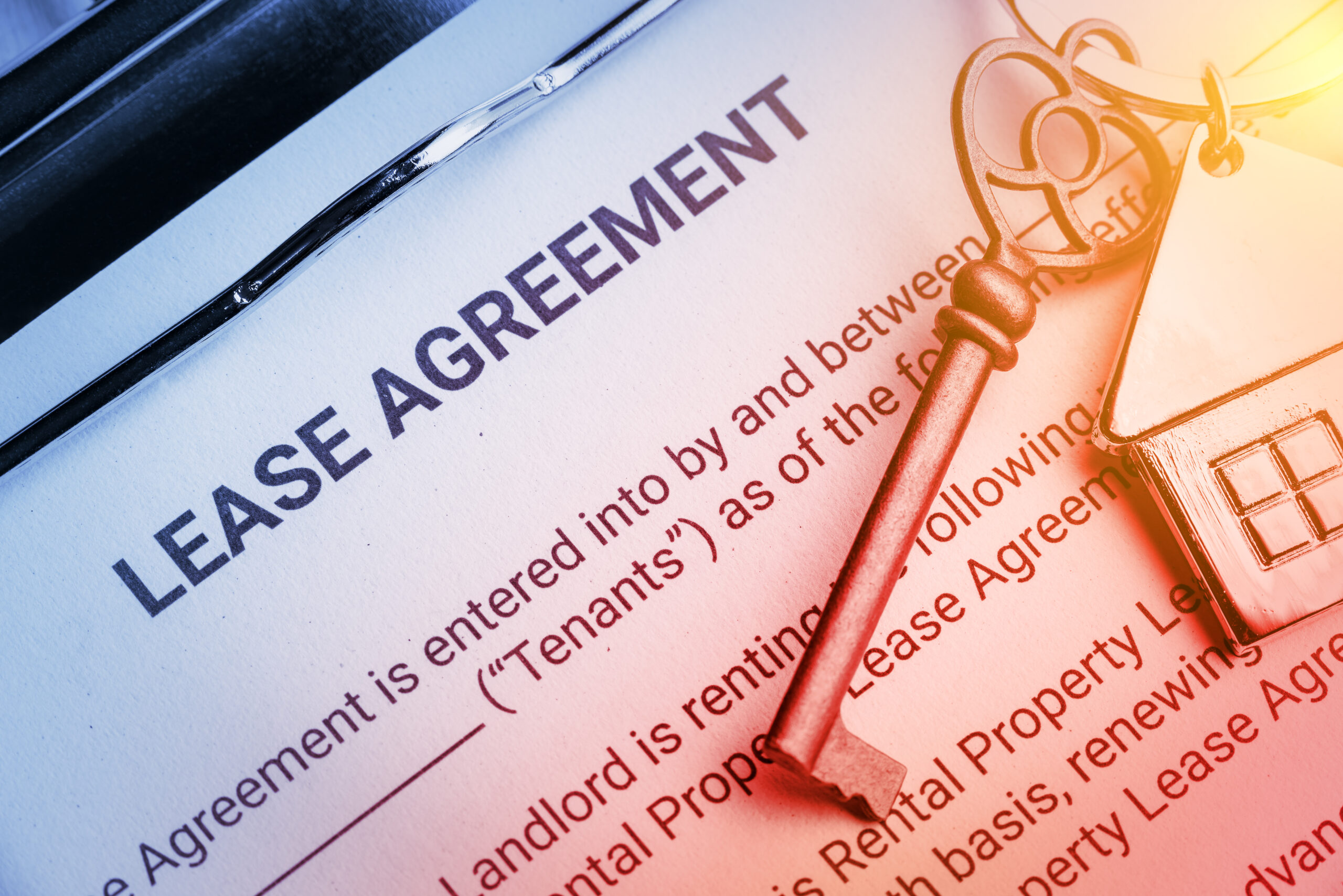 lease agreement for a property with a key sitting on a contract