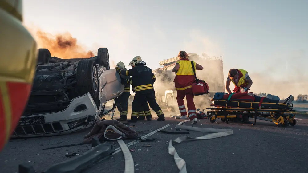 a person is trapped in a vehicle and firefighters and emergency personnel are extracting them