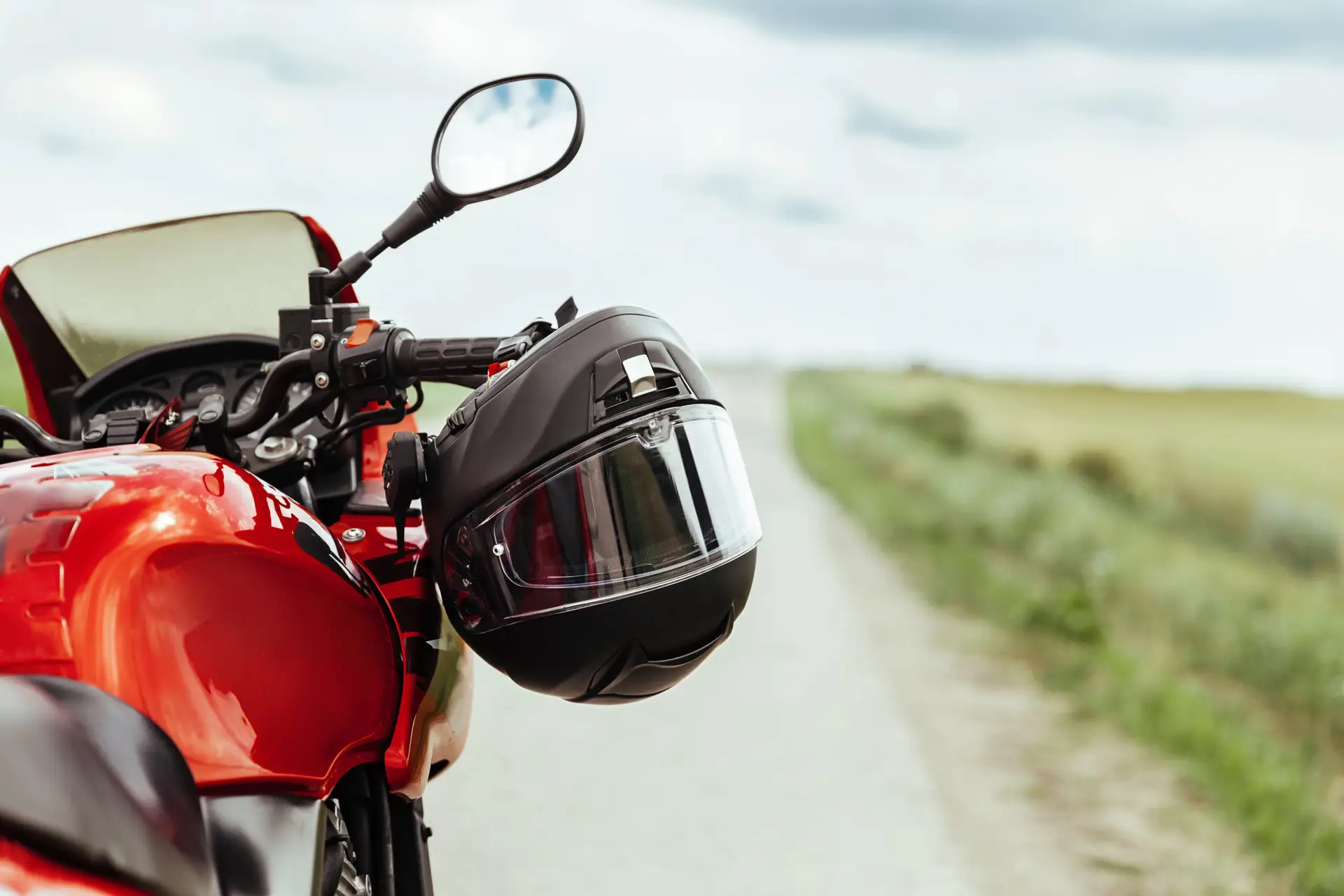 motorcycle helmet hanging off the handles of a parked motorcycle