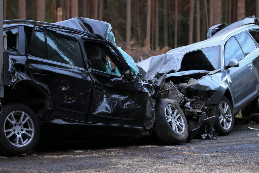 a black and a gray car wrecked from a head on collision