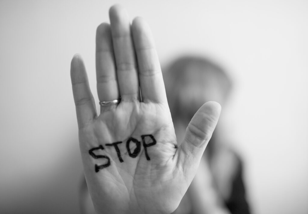 a hand outward in front of the camera with the word stop written in permanent marker
