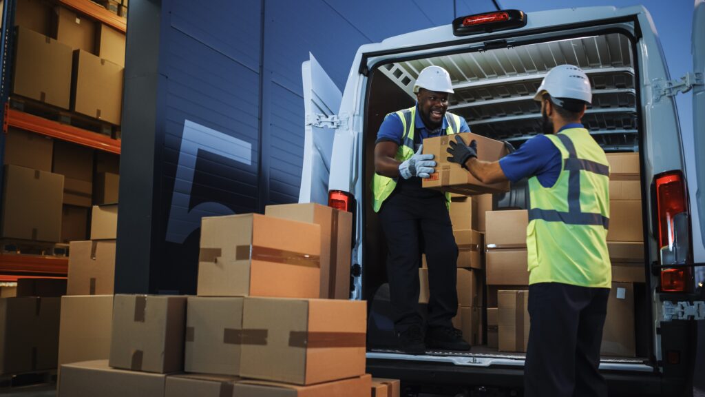 delivery truck being loaded by workers stacking boxes