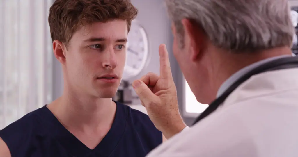 a doctor putting a young man through a concussion protocol