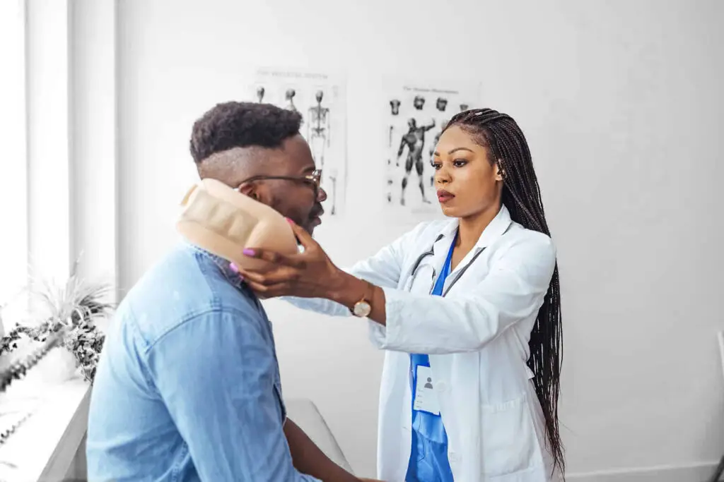 African american man wearing neck brace listening to doctor at hospital.