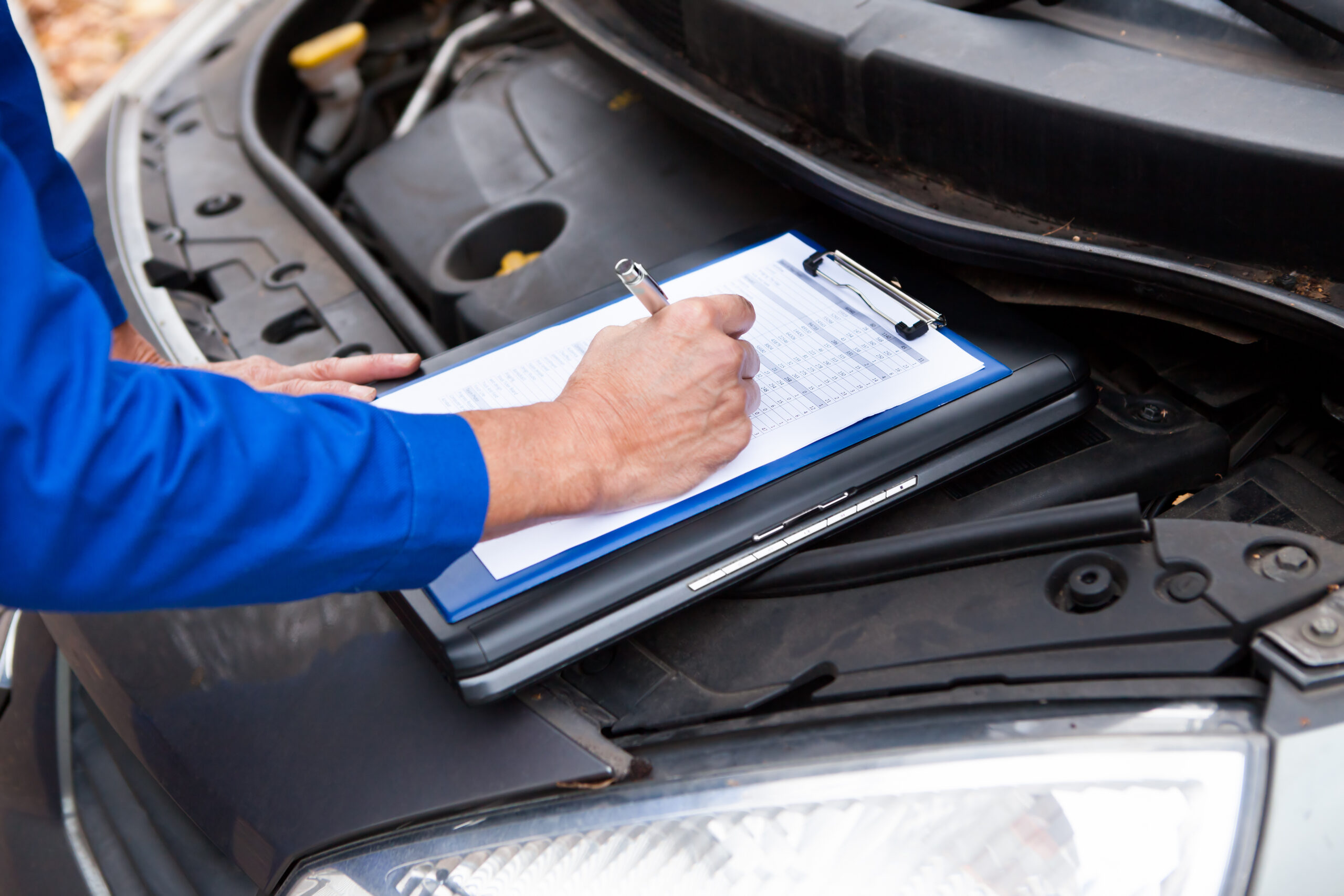 Close-up,Of,A,Mature,Mechanic,Maintaining,Car,Records