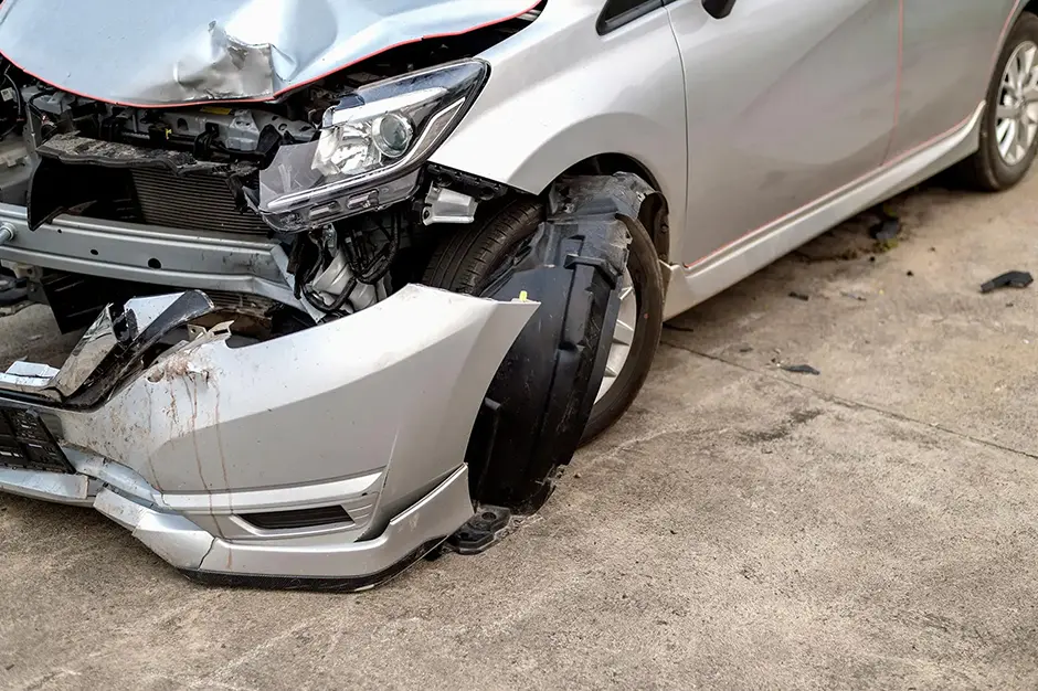 Closeup car in front has been damaged by accident with soft-focus and over light in the background