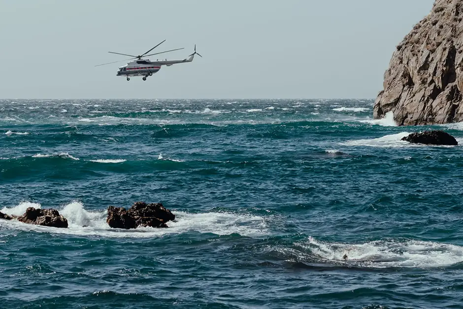 Helicopter flying over water to deliver oil rig workers